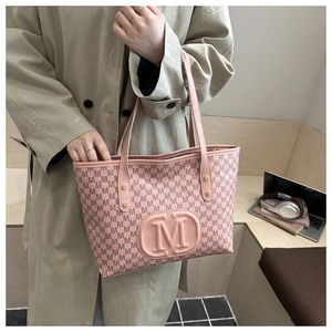 Close-up of pink tote bag with embossed M logo and letters for business casual style