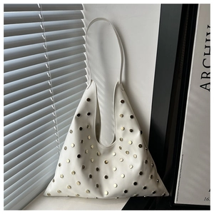 Vue détaillée du sac croissant blanc avec des rivets métalliques et jeux de lumière