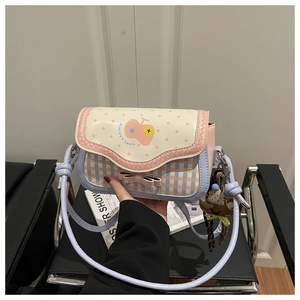 Detail of sweet plaid crossbody bag featuring pink bow, dot print, and plush doll charm