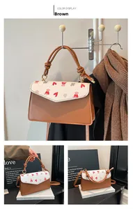 Detail view of the brown vintage crossbody bag with heart and bear prints and knot handle