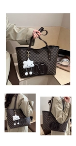 Detail of large brown tote bag with embossed M pattern and white cloud charm accessory