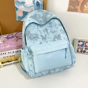 Light blue backpack with grey star and moon print featuring multiple zipper pockets