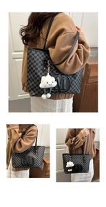 Detail of black large tote bag with M-letter print and white cloud plush charm