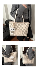 Detail view of the large capacity tote bag with embossed M pattern and cloud charm