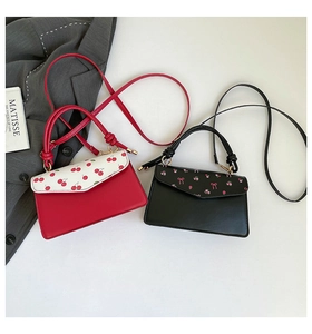 Flat lay of small printed PU leather crossbody bags with cherry and floral flap patterns