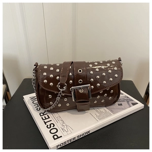 Detail view of brown patent leather bag with silver studs and large metal buckle decoration