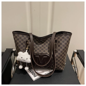 Close-up of large brown tote bag with M-letter print and white plush cloud charm