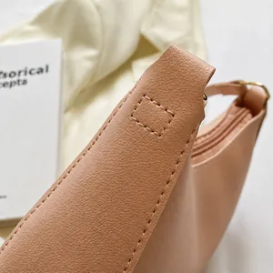 Detail der verstärkten Nähte und Litschi-Maserung an der nudefarbenen Handtasche