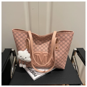 Pink monogram tote bag with embossed M logo and a cute cloud plush charm on a chair