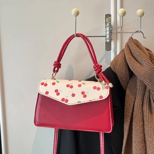 Stylish shoulder bag with red cherry prints and contrasting splicing on smooth leather