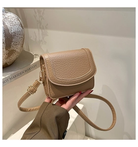 Close-up of khaki brown pebble grain leather handbag with gold-tone hardware detail