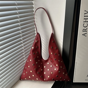 Sac bandoulière triangulaire en cuir rouge avec rivets métalliques dorés décoratifs