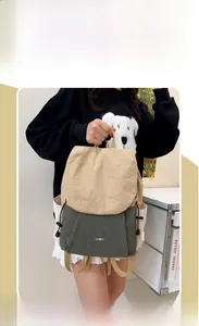Detail view of the beige and dark green nylon travel backpack with side pockets