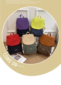 Close-up of five colorful contrast nylon travel backpacks on a stylish woven carpet