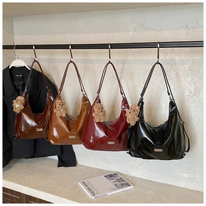 Detail showing high-gloss Hobo bags in four colors with cute plush bear charms attached
