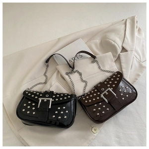 Detail of punk style crossbody bags with silver rivets and metal buckle in black and brown