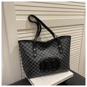 Close-up of embossed M logo on large capacity tote bag with monogram print detail