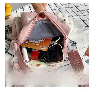 Interior view of small pink canvas crossbody bag showing phone, lipstick and sunglasses