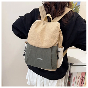 Detail view of khaki and dark green nylon backpack with drawstring side pocket