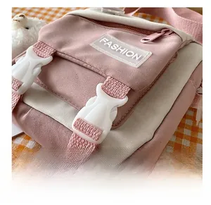 Detail shot of the secure plastic buckles and pink canvas texture on the crossbody bag