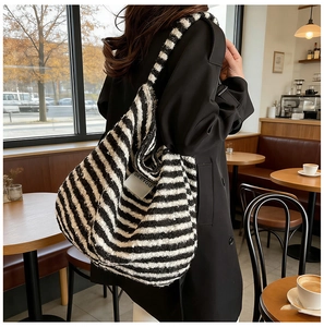 Detail of black and white striped tote bag showing textured fabric and BEE YOU woven label
