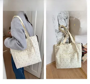 Detail view of cream canvas tote bag with black polka dots and large front pocket flap