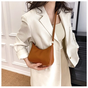 Bolso bandolera de media luna color caramelo con correa ajustable en ambiente casual