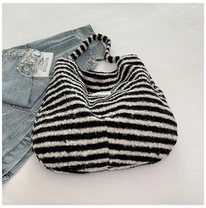 Detail of black and white striped plush tote bag with soft texture and wide shoulder strap