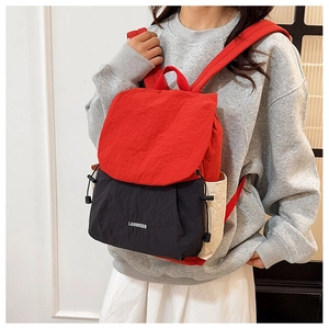 Detail of color-block travel backpack with drawstring closure and flap cover design