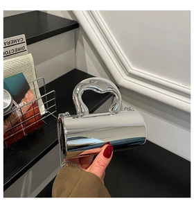 Silver metallic cylinder bag with shiny finish, chunky handle and chain strap