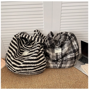 Macro view of plush tote bags with striped and plaid patterns and Seeyou label