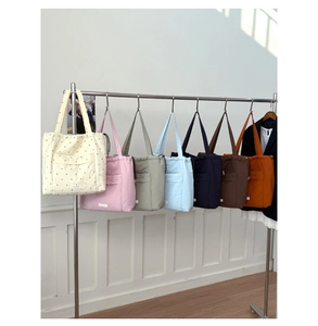 Detail showing the colorful variety of minimalist drawstring tote bags on a rack