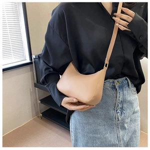 Detailaufnahme einer minimalistischen nudefarbenen Leder-Mondtasche mit Goldbuckle