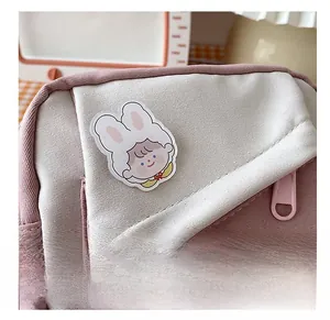 Detailed close-up of pink and white canvas bag with cute cartoon girl patch and fashion label