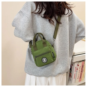 Close-up of grass green nylon crossbody bag with adjustable strap and brand logo