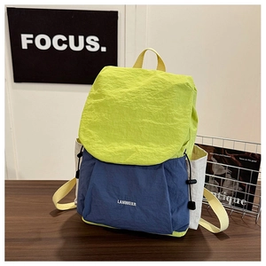 Detailed close-up of textured nylon patchwork backpack on a wooden table setup