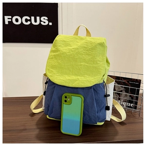 Detail of color-block nylon backpack with drawstring closure and green smartphone comparison