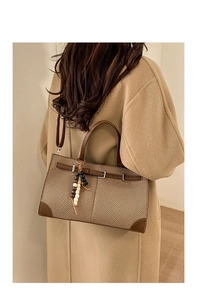 Detailansicht der Retro-Webtasche mit Lederriemen und dekorativem Holzperlen-Anhänger