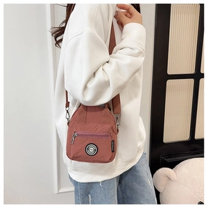 Mini nylon crossbody bag in rose pink worn by a model to show the actual scale and fit