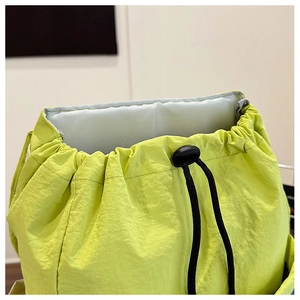 Close-up of lime green drawstring bag showing nylon texture and black adjustable cord
