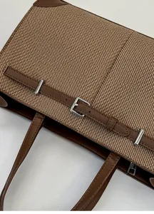 Detailsicht des gewebten Materials und braunem Lederriemen mit silberner Schnalle der Tasche