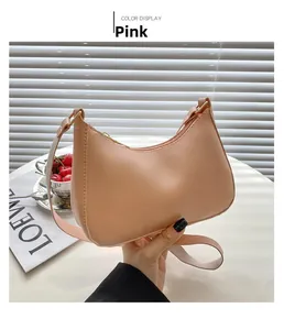 Detailansicht einer rosa Halbmond-Hobo-Bag aus PU-Leder mit goldfarbenen Metallbeschlägen