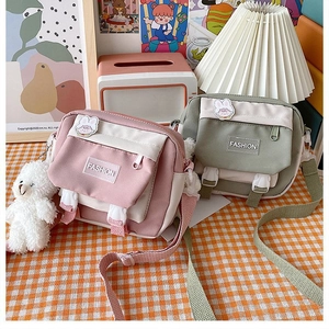 Detail of pink and green canvas crossbody bags with cute bunny pin and bear keychain