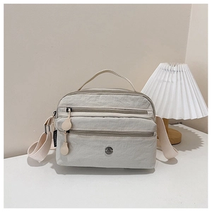 Close-up of lightweight nylon crossbody bag featuring multi-layer zipper compartments