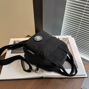 Minimalist black nylon crossbody bag with adjustable strap and multiple pockets