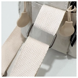 Close-up of lightweight nylon shoulder bag showing adjustable strap and silver metal hardware