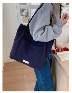 Deep blue canvas tote bag showing its large capacity and casual style on a female model