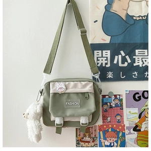 Detail of canvas crossbody bag showing fashion label, rabbit patch, and alpaca charm