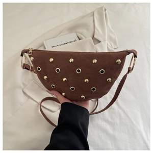 Détail du sac demi-lune en daim café avec des rivets dorés et anneaux en métal