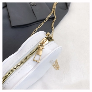 Detail der weißen herzförmigen Jelly-Tasche mit glänzendem Finish und goldener Kette